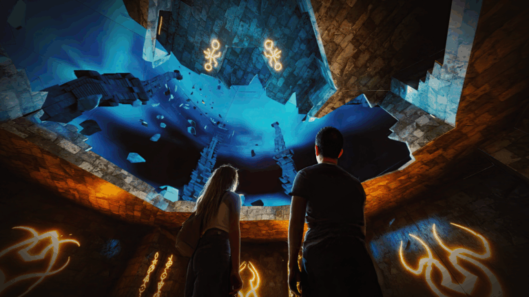 Two people look to the ceiling as the interactive Lost World AV experience transforms.